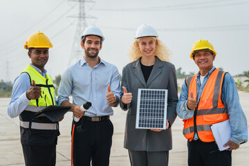 Three people are standing together, one of them holding a solar panel