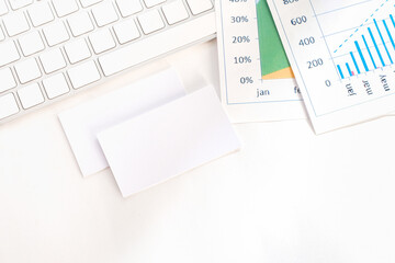 Empty visiting cards, a keyboard and documents are on the workplace