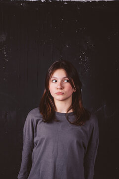 Girl with sideways glance in front of black background
