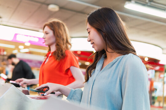 Young friends scanning QR code through smart phones at station