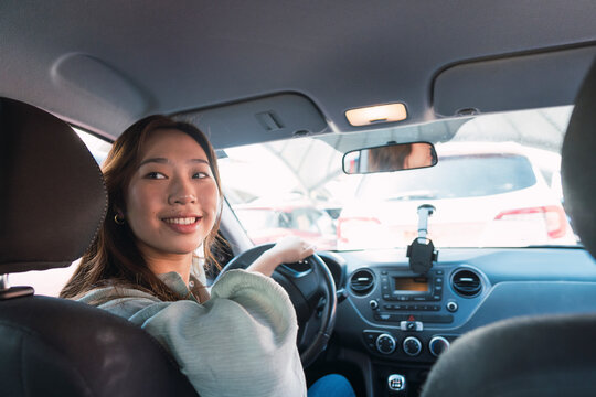 Smiling woman looking over shoulder sitting in car