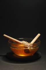 Yellow liquid honey dripping from the honey spoon