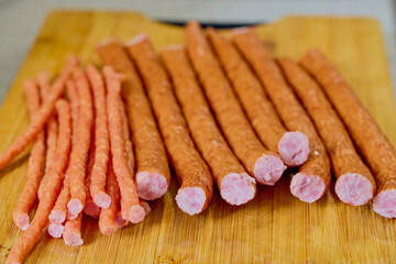 sausages on a wooden board ready to be cooked.