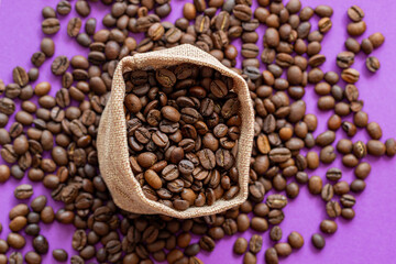 coffee beans  in burlap bag on the background, coffee beans in a burlap bag on the purple background with a place for inscription. on coffee beans background