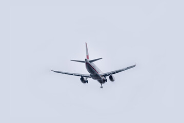Fototapeta na wymiar Commercial airplane flying against overcast sky