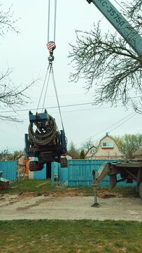 A crane lifting a machine for well drilling. Preparation for the boring of the water pore in the rural area. Vertical video.
