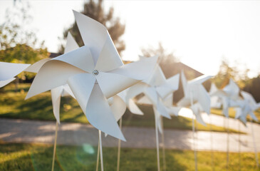 White childrens wind turntables on the lawn in front of the house. A collection of windmills as a...