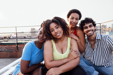 A young multi-ethnic group of smiling friends hugging each other. Portrait photo of young cheerful...