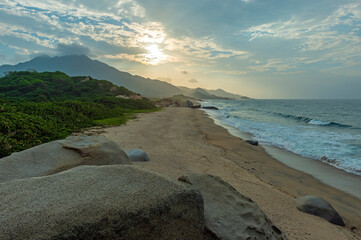 Beach at sunset with rock boulders, Tayrona national park, Santa Marta, Colombia.