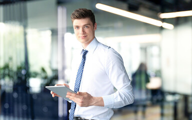 Young businessman standing in office with his collegue on the background - 779506652