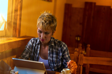Plaid-clad, absorbed in tech, wooden surroundings