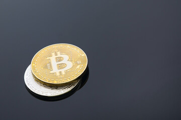 Golden and silver bitcoin cryptocurrency on black background