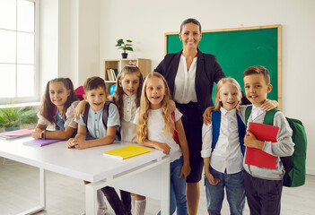 First day of school year. Classroom portrait of group of primary school students and their female...