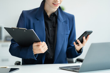 Business woman or financial data analysts working with smartphone and laptop computers and data...