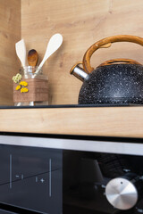 granite kettle, ceramic stove and kitchen spatulas