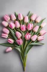 Delicate neat bouquet of light pink tulips on a gray concrete background. View from above.