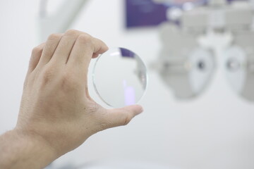 close up of a doctor holding a lens glasses in optical store 
