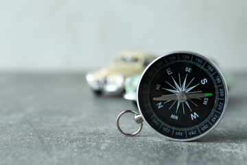 A compass on a table with a car.
