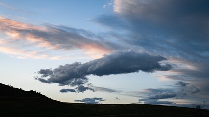 Beautiful background of fluffy clouds in the sky at sunset over the hill
