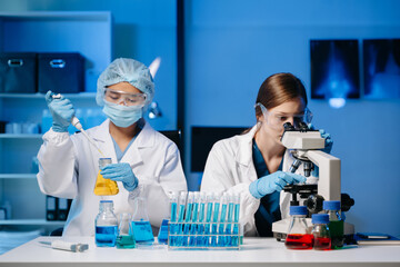 Young scientists conducting research investigations in a medical laboratory, a researcher in the...