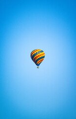 Vertical of a colorful hot air balloon captured in the beautiful cloudless sky