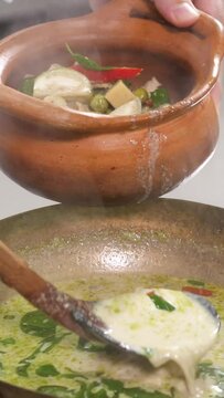 chef preparing food Green curry in a clay pot asian food verticle video
