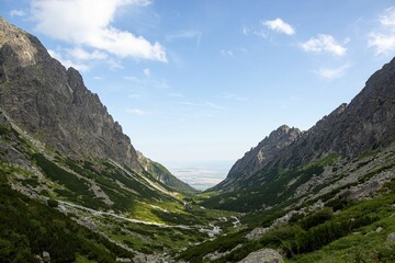Fototapeta na wymiar Breathtaking view of a green valley surrounded by rocky cliffs in the High Tatras range in Slovakia