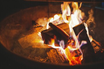 Hot dog being cooked on a campfire at night