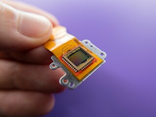 Macro shot of a digital camera Ccd sensor in the hands of a  person on a purple background