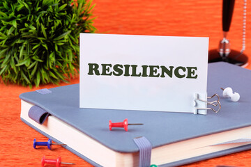 RESILIENCE on a white business card standing on a notepad