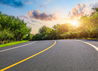 Asphalt road and green trees with sky clouds background