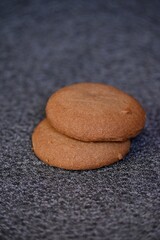 Fototapeta na wymiar Closeup vertical shot of two brown cookies on the table