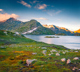 Colorful summer sunset on Totensee lake. Green evening landscape of Grimselpass, Switzerland, Europe. Majestic outdoor scene of Swiss Alps, Bern canton. Beauty of nature concept background.. - 779557023