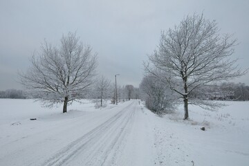 The snow has been plowed from the road in cold cloudy winter weather, Haltiala, Helsinki, Finland.