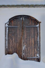 Old weatherd brown wooden door on a stone building.