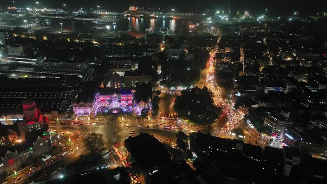 Aerial view of a busy road intersection in front of Chhatrapati Shivaji Maharaj Terminus train station in Mumbai, Traffic at CST Station. Shot of Mumbai Skyline, high-rise buildings in South Mumbai. 