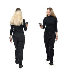 back and front view same woman walking and looking at the smartphone on white background - 779572048