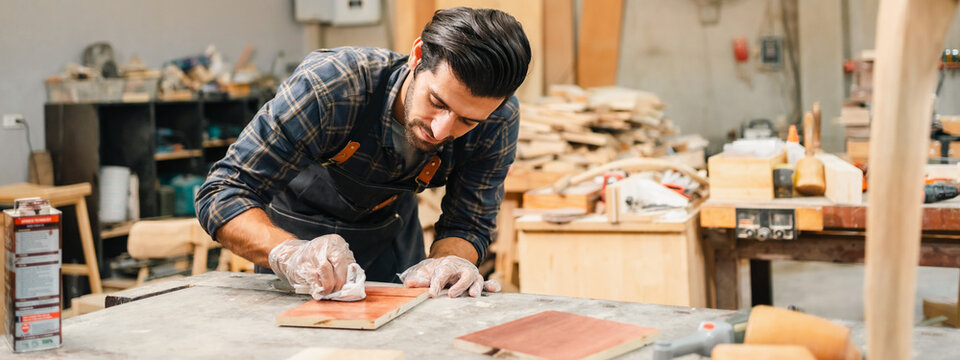 Diligently skilled man work with wood in carpenter's shop, using tools and equipment to transform timber planks into bespoke wooden pieces, craftsmen workshop with natural material, furniture industry
