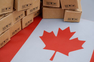 Canadian industry concept. Flag of Canada and many shipping carton boxes close-up.