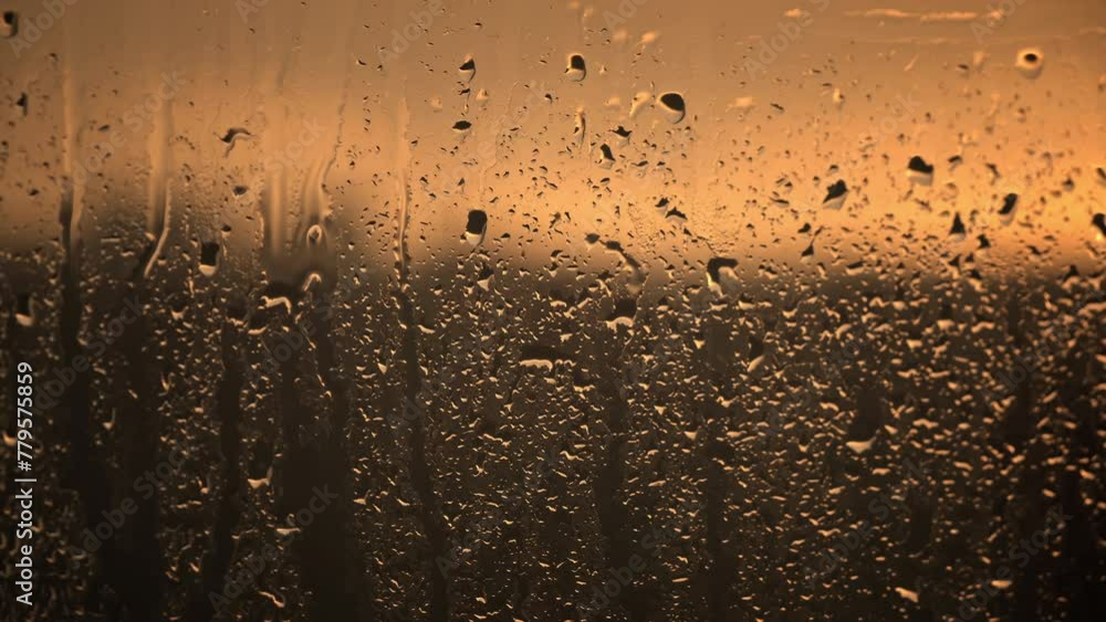 Poster the warm hues of a setting sun illuminate the raindrops on a window, creating a soothing, glowing pa