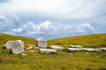 Necropolis of tombstones on Visocica mountain range under a  blue cloudy sky