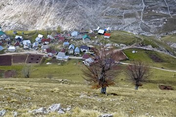 High angle shot of rural houses on the slopes of a mountain on an autumn day