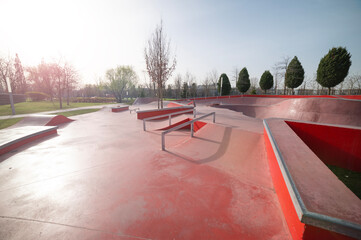 Empty public red skate park waiting for skaters. Skateboard in city. Skate and Bike Park. Extreme sports ground