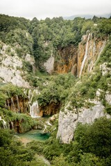 Gorgeous vertical shot of the Plitvice Lakes National Park with bushy trees and waterfalls