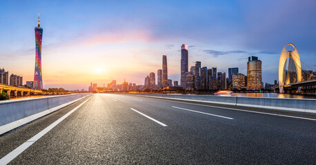 Asphalt highway road and city skyline with modern buildings at sunset in Guangzhou. Panoramic view.
