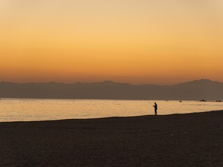 Fototapeta premium Silhouette of a fisherman on a seashore at sunset in Turkey