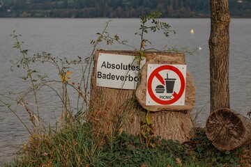 Lakeshore with signs banning swimming and eating in the area