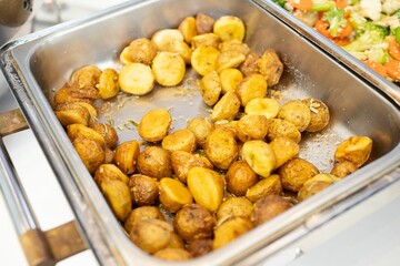 High-angle shot of the freshly baked potatoes on the pan at the cafeteria