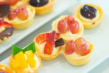 Closeup shot of tasty and sweet tartlets with fruits put on the white plate