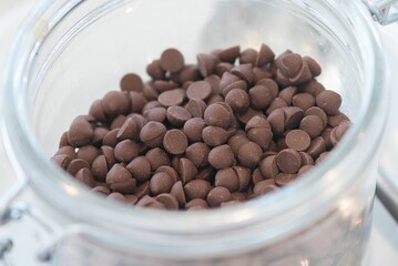 Closeup shot of the small pieces of the milk chocolate put in the glass jar